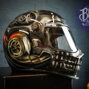 Black motorcycle helmet with detailed skull and snake airbrush design featuring golden accents and realistic death imagery